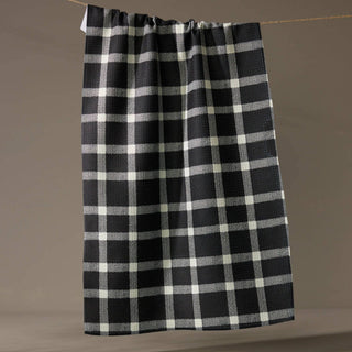 Black and white checkered towel hanging on a line against a brown background