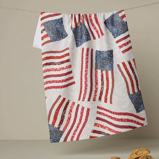 Tea towel with American flag pattern hanging on a line, with cookies on a plate below.