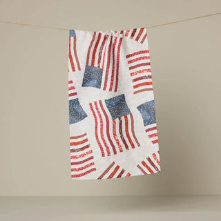 Towel with American flag pattern hanging on a line against a beige background. Geometry tea towel