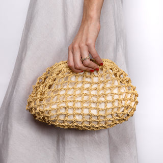 mesh clutch held by a person wearing a light gray dress on a white background