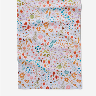 Floral patterned tea towel with colorful flowers and leaves on a white background