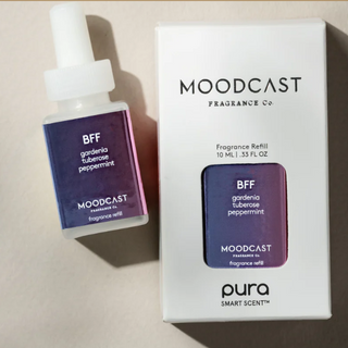 Moodcast Fragrance Co. BFF gardenia tuberosa peppermint fragrance refill bottle next to its white retail box, featuring a purple-to-pink gradient label.