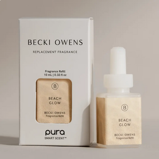 Becki Owens Beach Glow fragrance refill set, featuring a white product box and a small amber glass dropper bottle with a white cap, both labeled 'Beach Glow' and 'Becki Owens'.
