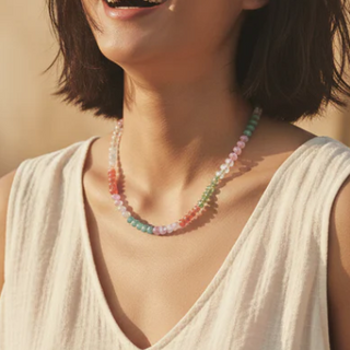 Woman wearing a colorful beaded necklace against a blurred natural background