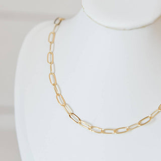 Gold chain necklace on a white mannequin bust